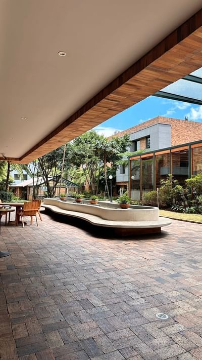 The hotels in Bogota courtyard at Habitel Hotel Select with a large fountain, surrounding trees, and an open seating area