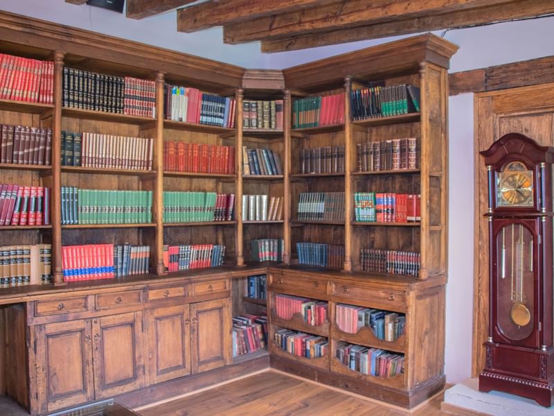 Bookshelf & a clock in Biblioteca Stanza Room at Gamma Hotels