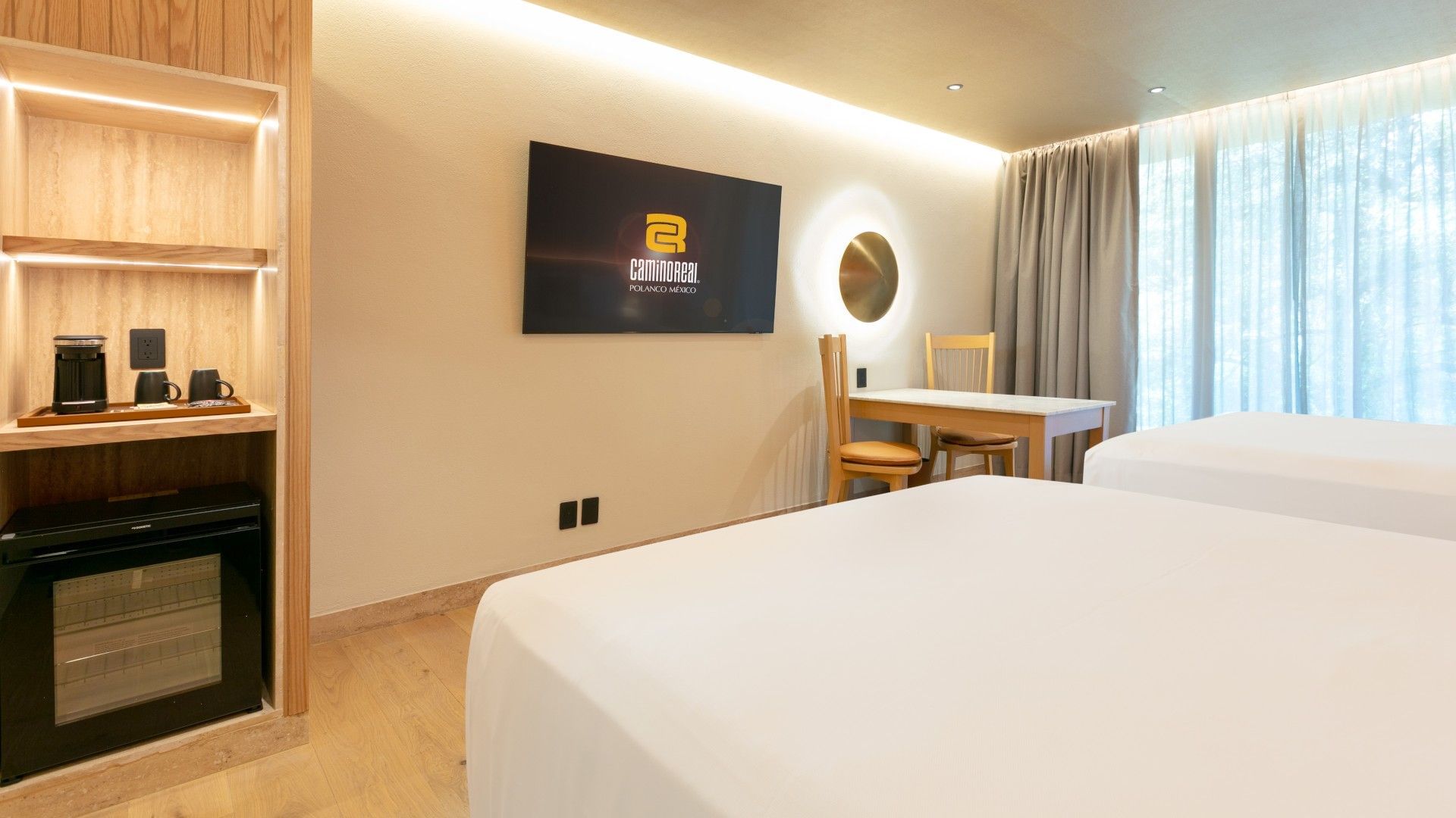 2 Double Deluxe Plus room with a wall-mounted TV, small dining table, and white linens at Camino Real Polanco Mexico