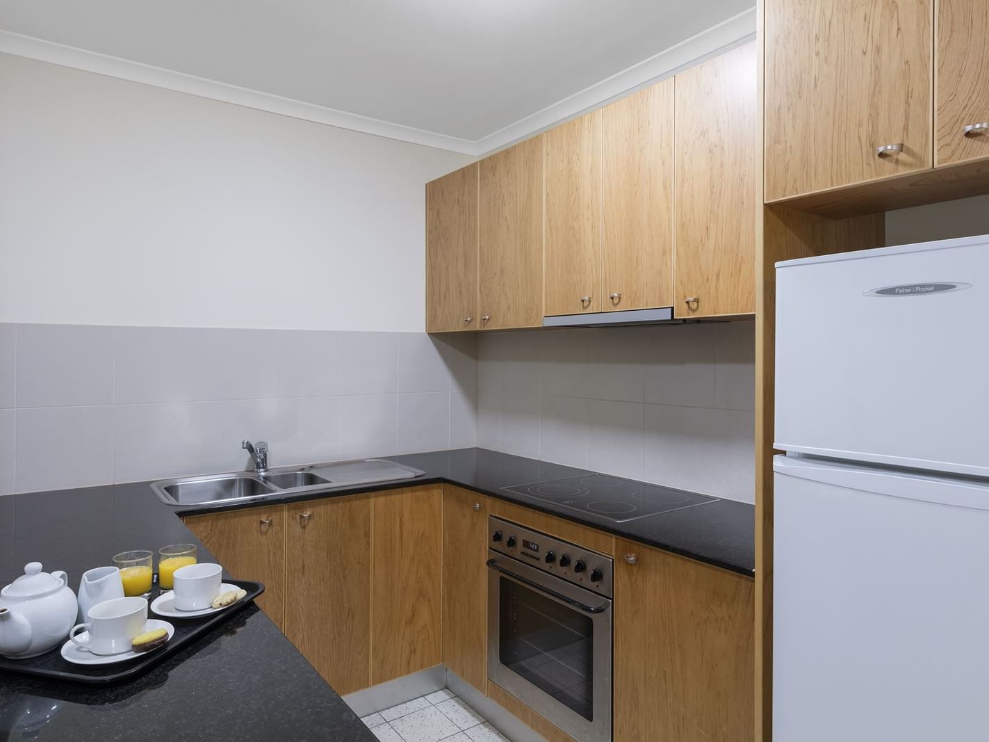 Modern kitchen with appliances in a   room at Nesuto Canberra Apartment Hotel