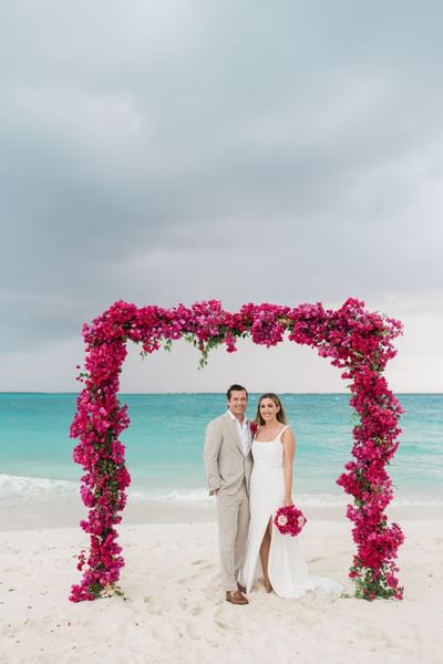 Wedding couple with flower arch at The Somerset on Grace Bay