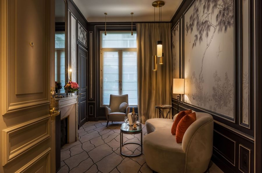 TV lounge with plush sofa by the window in Deluxe Parisienne Suite at Hotel Westminster Paris