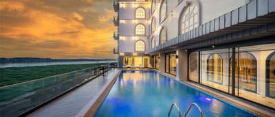 Outdoor pool area with city view captured during sunset at Eastin Hotels