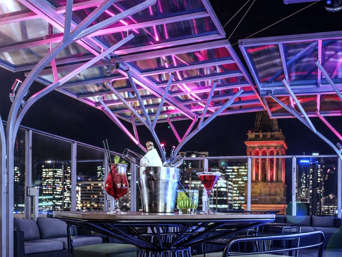 Illuminated SIXTEEN ANTLERS ROOFTOP BAR with cityscape view at Pullman Brisbane King George Square in Brisbane City.