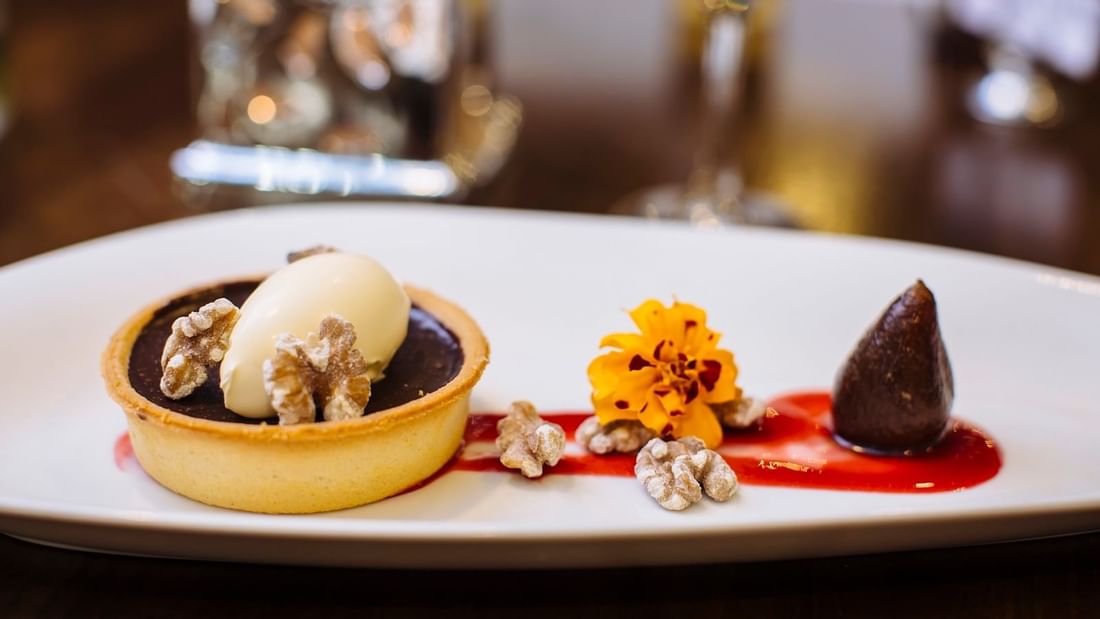 Chocolate tart topped with vanilla ice cream, walnuts, and raspberry sauce at Mercure Hotel Townsville 