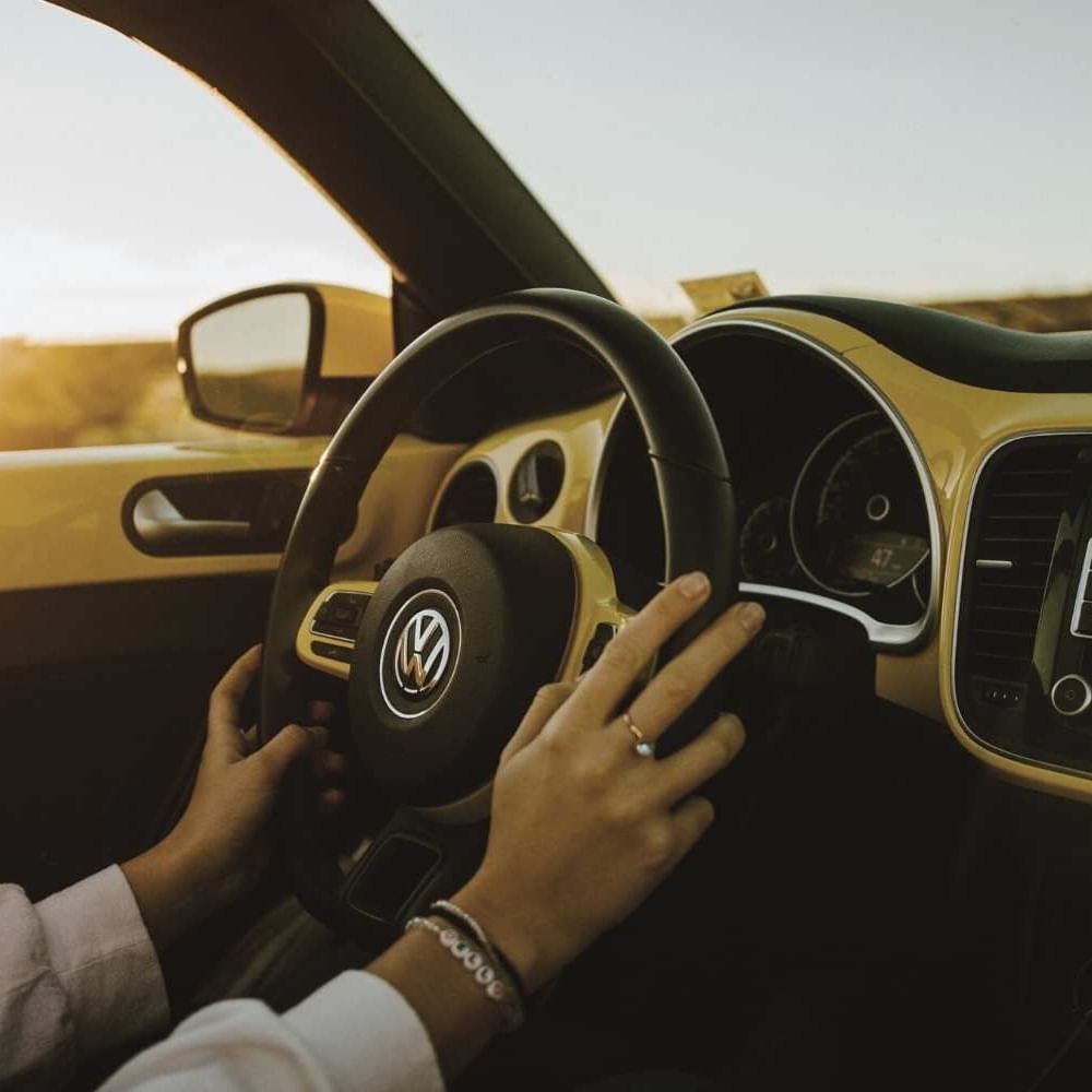 Close-up of hands on a Volkswagen Beetle steering wheel near Waikiki Resort Hotel by Sono