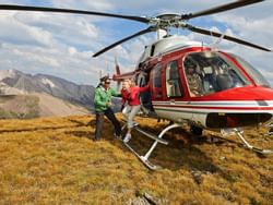 Women getting off a helicopter near Blackstone Mountain Lodge