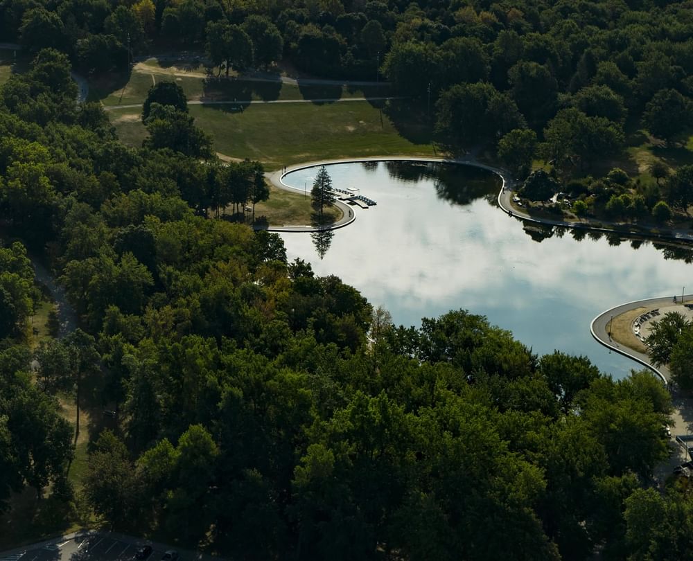 Aerial view of Montreal skyline with park pond, lush greenery, and river in the distance at Warwick Le Crystal Montreal