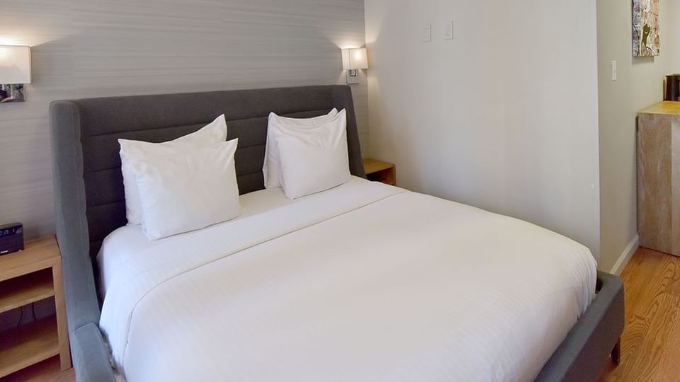 A hotel room with a large bed, two nightstands, and a window.