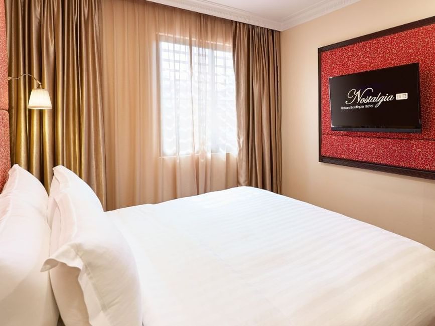 King-size bed with comfy pillows & TV Executive Room in Nostalgia Hotel Singapore