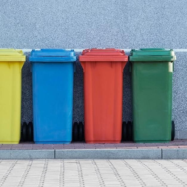 A variety colors of garbage bins lined up outdoors at Sofitel Brisbane Central