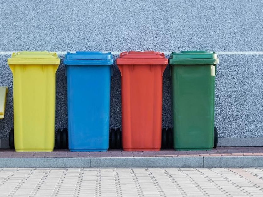 A variety colors of garbage bins lined up outdoors at Sofitel Brisbane Central