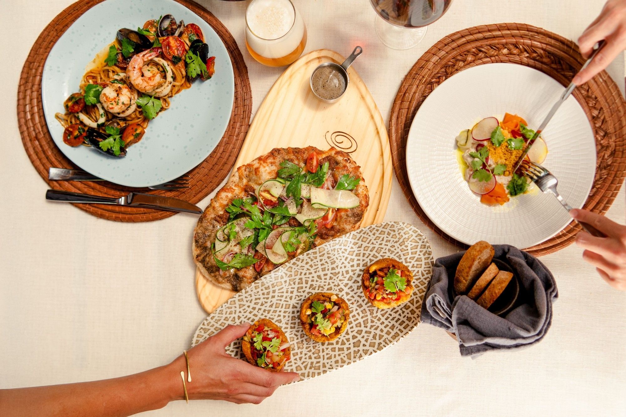 Tropical dining spread featuring seafood pasta, flatbread, and authentic snacks served at Cala Luna Boutique Hotel