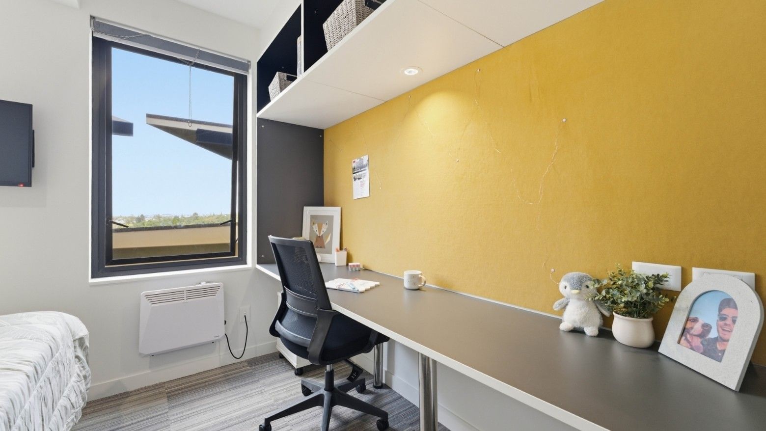 Modern room with desk, chair, and bed at UniLodge Auckland City.