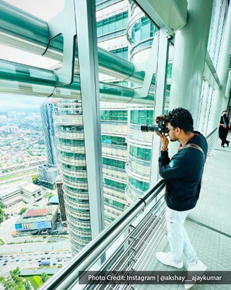 Man photographing the view from the Sky Bridge of Petronas Twin Towers, a famous attraction near Imperial Kuala Lumpur