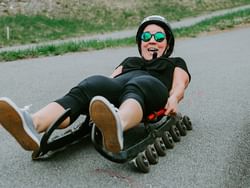 Closeup of a girl doing Street Luge on a road near Peaks Resort
