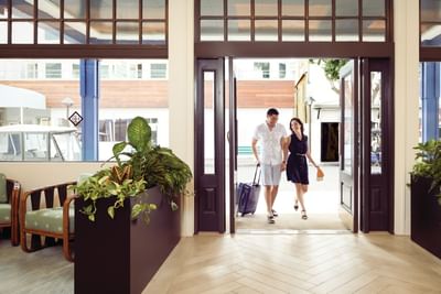 A couple arriving to the hotel with a suite case at Hotel Atwater