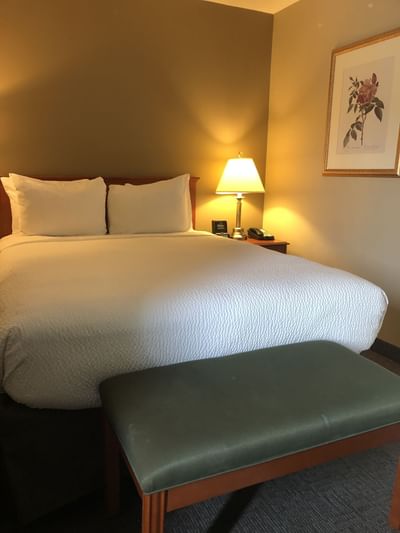 Cozy bed with lamp in Queen Suite with Jetted Tub at Hotels in Fort McMurray