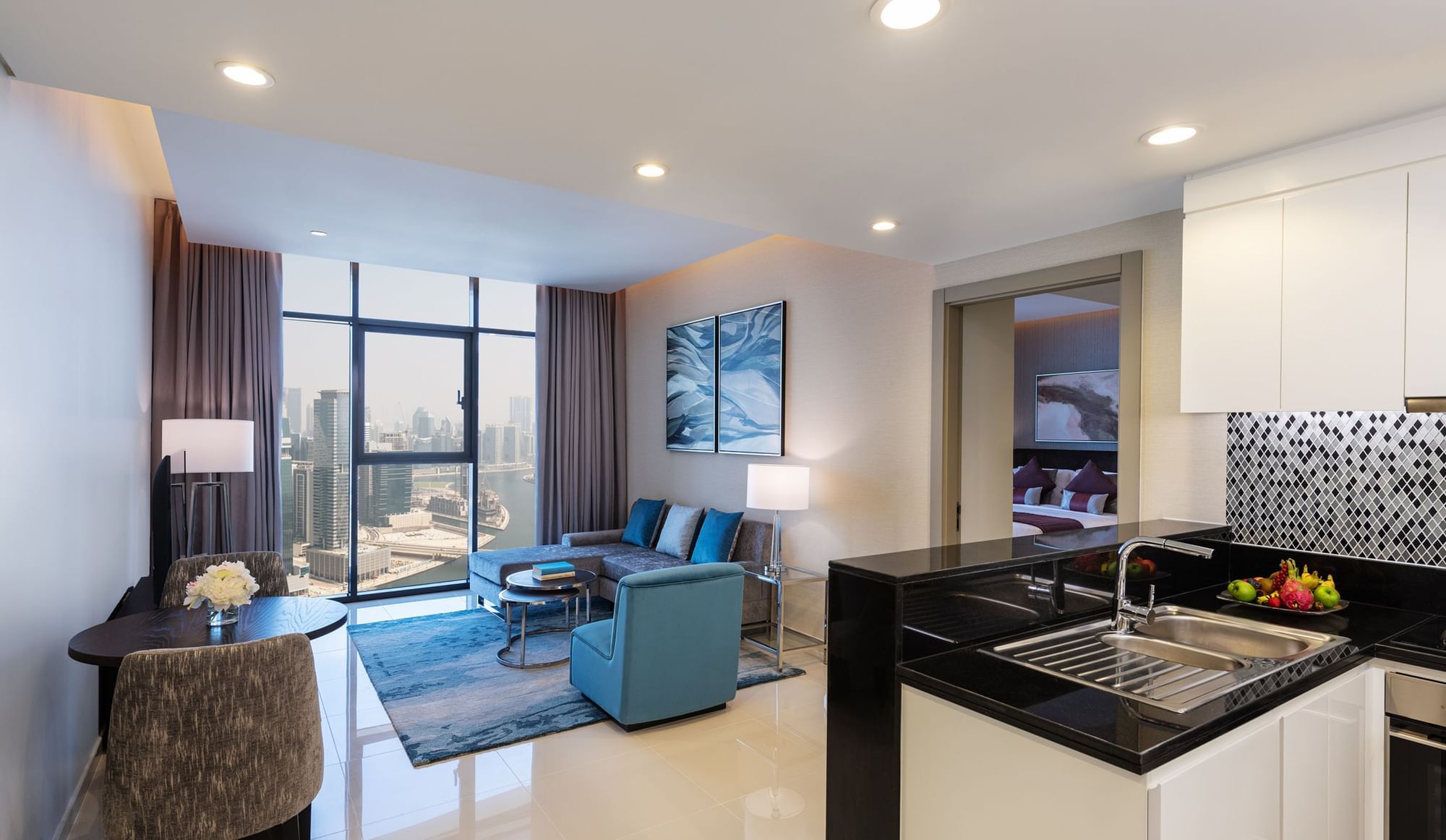 Interior of living area, kitchen, and city view in Three Bedroom at DAMAC Maison Aykon City