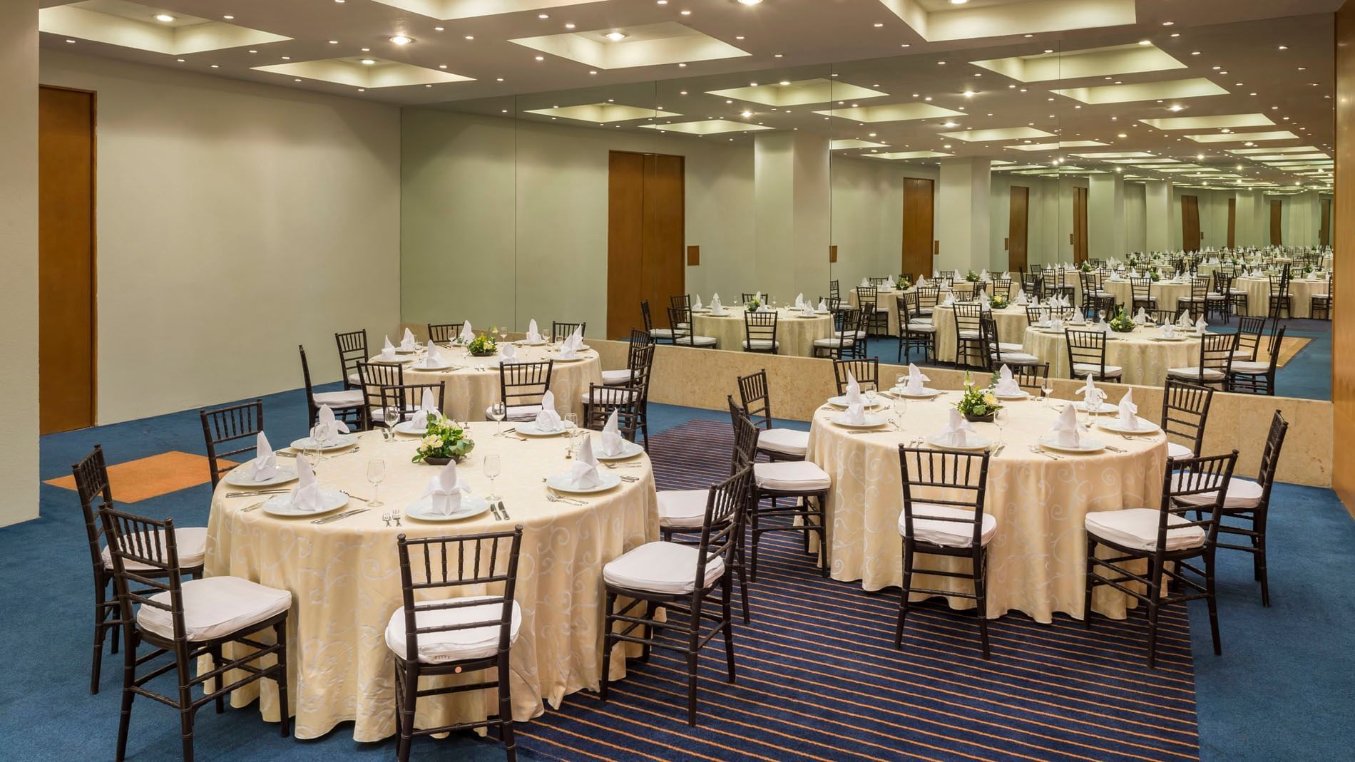 Sala de eventos CDMX con mesas y sillas en Real Inn San Luis Potosí.