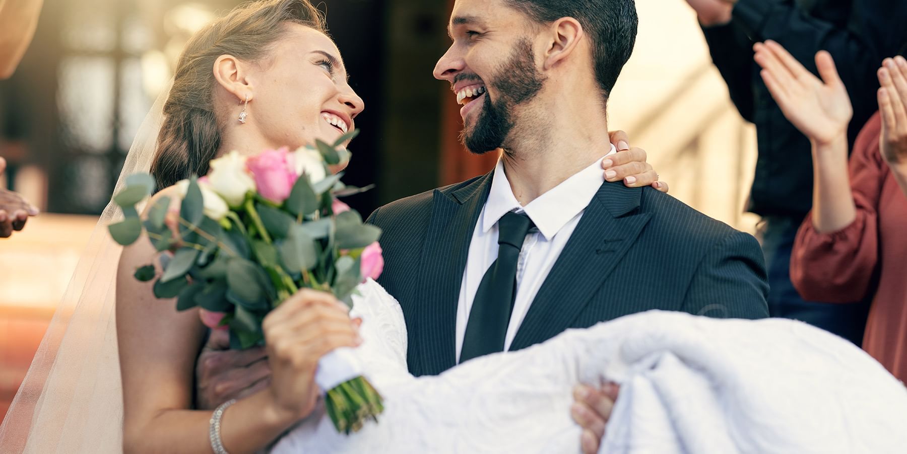 Groom holding bride with flower bouquet at Listel Whistler, a Coast Hotel