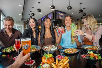 Group of people enjoying drinks and meals at Hotel Clique Calgary Airport