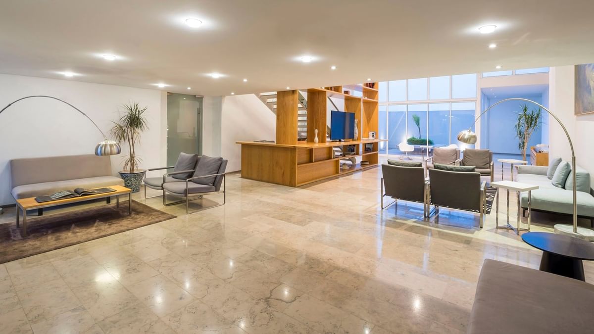 Modern lobby lounge featuring sleek marble floors and stylish seating at Camino Real Puebla Angelopolis