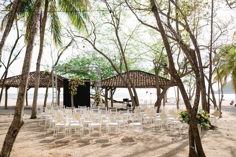Chairs in rows by a floral arch under trees at Morgan's Rock, featuring an eco luxury lodge Nicaragua with private beach