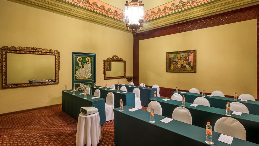 Salón Virreinal meeting room featuring a projector and rows of bottled water at Quinta Real Aguascalientes