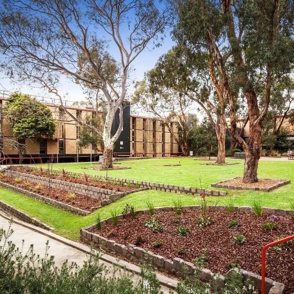 La Trobe University Menzies College buildings and gardens with a red handrail on the right.