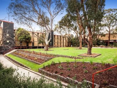 La Trobe University Menzies College buildings and gardens with a red handrail on the right.