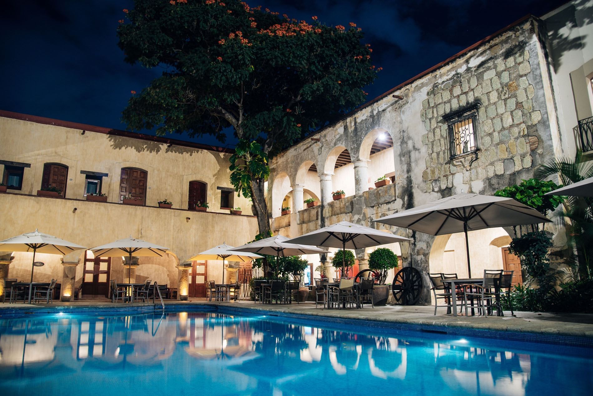 Historic courtyard with arched stone architecture surrounds a rectangular pool at Alberca Salon in Quinta Real Oaxaca