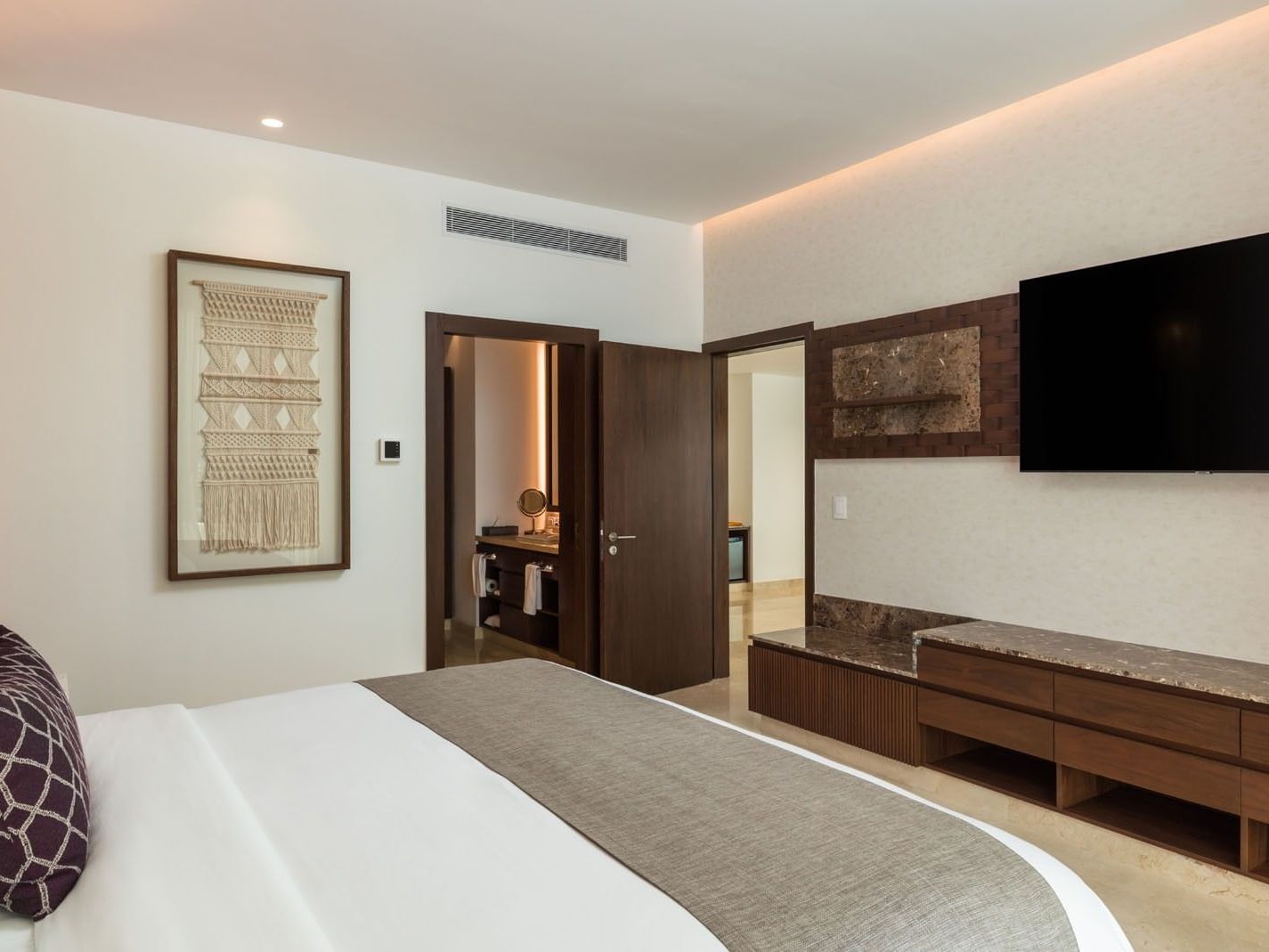 King Presidential Suite featuring a king bed, wooden dresser, and woven wall art decor at Camino Real Merida