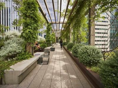 Urban garden with benches under a vine-covered pergola at West Tower Melbourne Quarter.