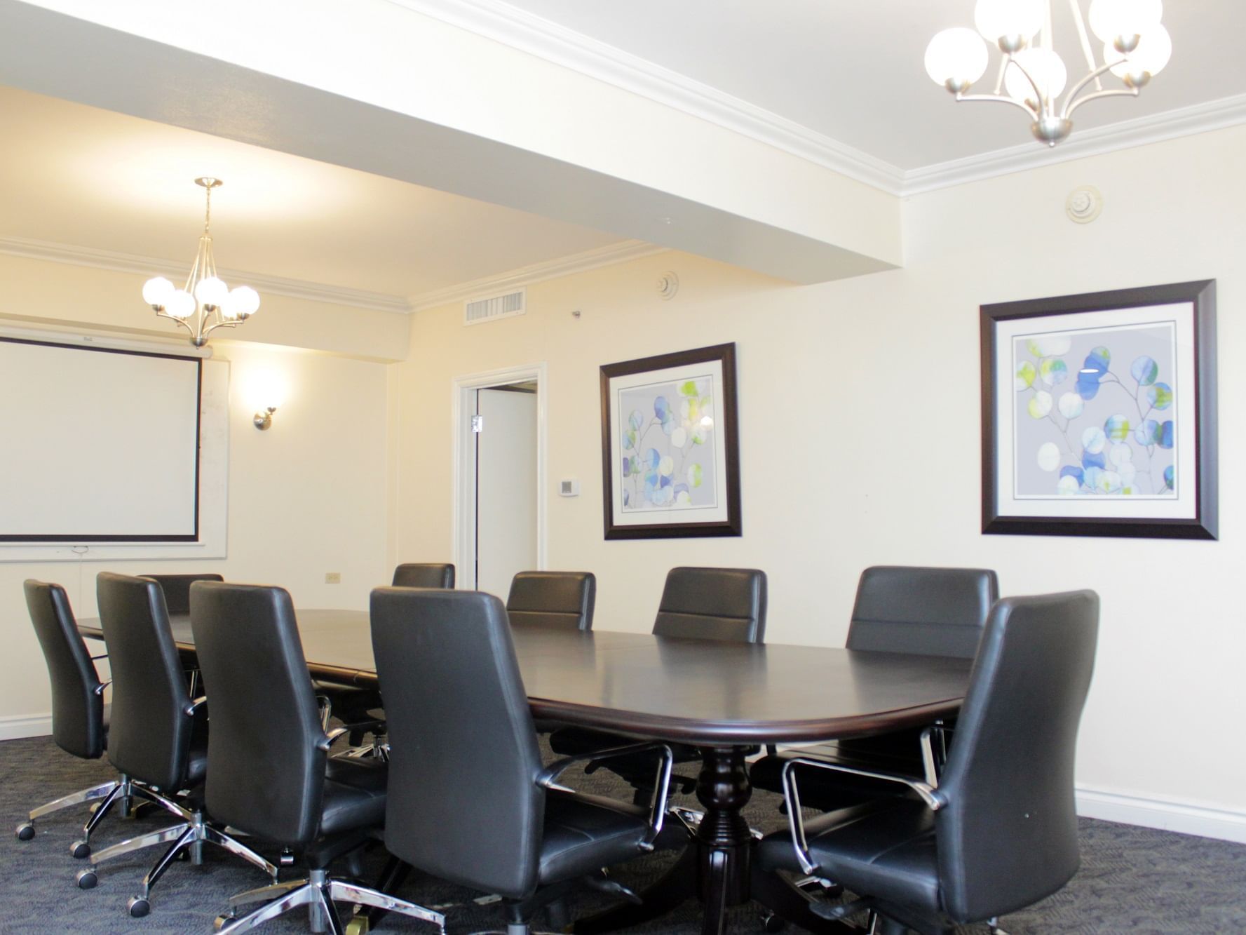Boardroom set-up with a projector screen in Marcus Garvey at Jamaica Pegasus Hotel