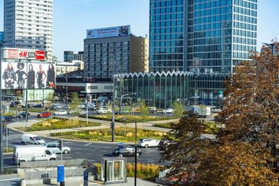 Distant view of Rotunda PKO Bank Polski with vehicle on the road near Metropol Hotel