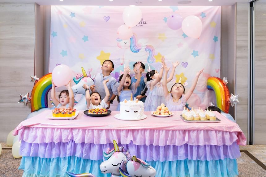 香港百樂酒店獨角獸主題兒童派對，多位小朋友在彩虹與獨角獸佈置前開心玩氣球與享用生日甜點