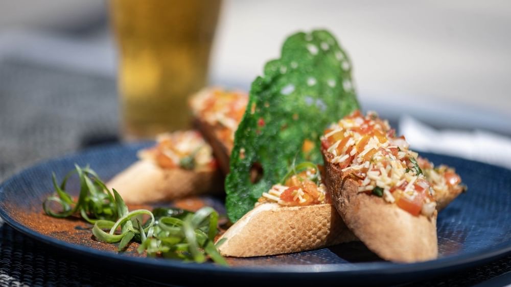 Delicious tomato bruschetta appetizers served on a blue plate in Pool Grill & Bar restaurant at warwick le lagon-vanuatu
