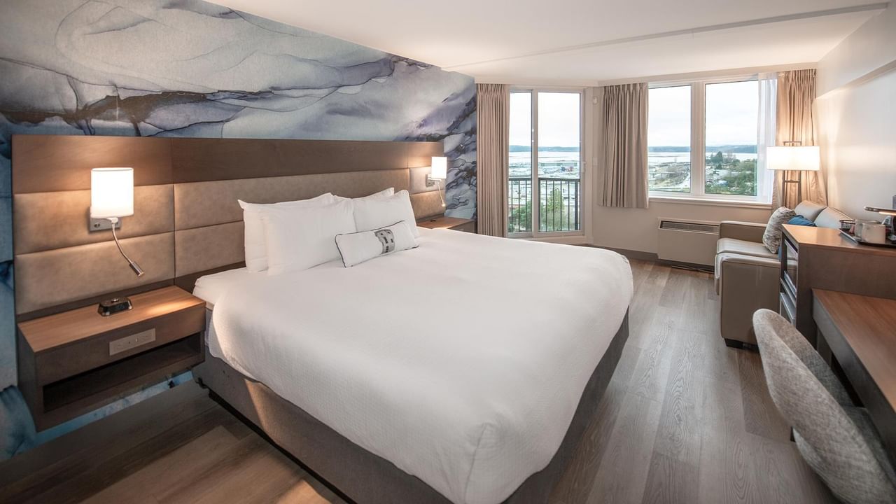 King bed, couch, chair, and balcony with a view at Coast Bastion Hotel in Nanaimo.