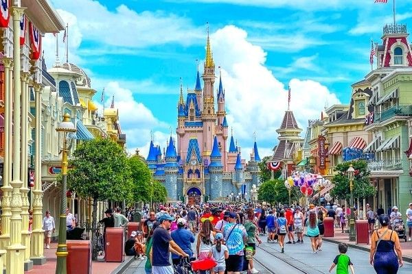 Main Street USA at Magic Kingdom, with Cinderella Castle at one end of the street and crowds of people walking past.