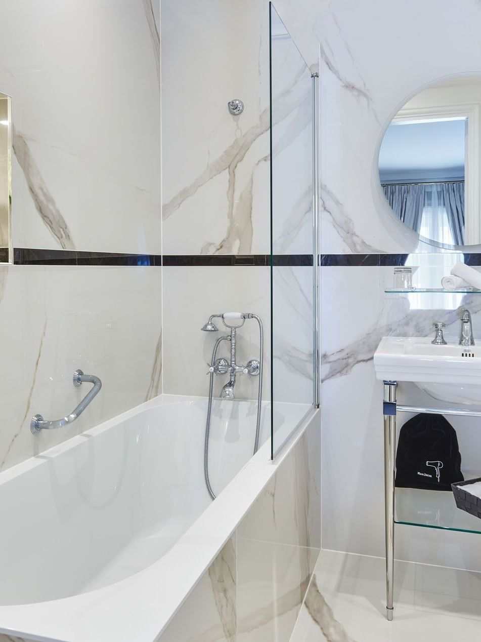 Prestige Suite – Rue de la Paix View bathroom featuring a marble vanity by the bathtub at Hotel Westminster Paris