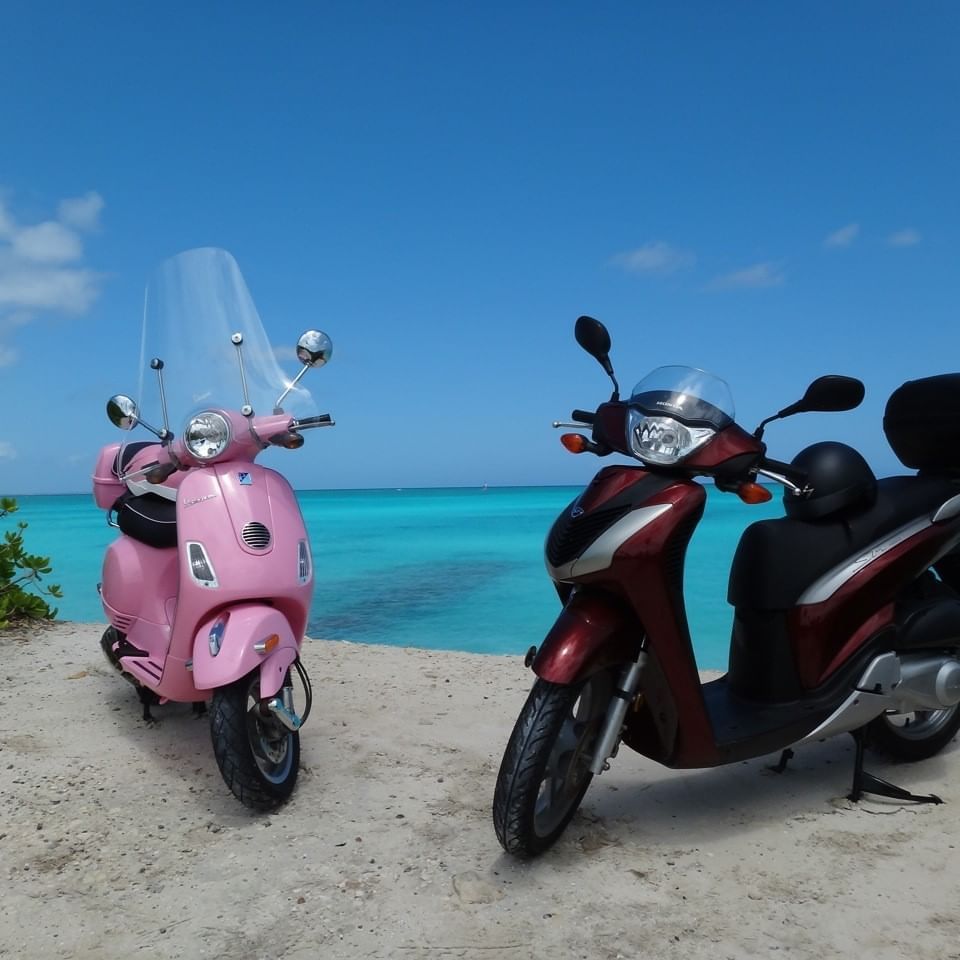 Two scooters parked by the bay near The Somerset on Grace Bay