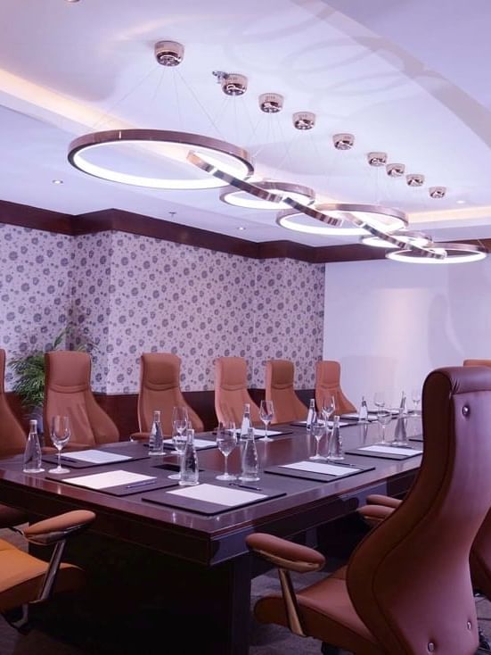 High-back tan leather chairs surrounding a dark wood conference table in Pearl 1 at Warwick Al Khobar