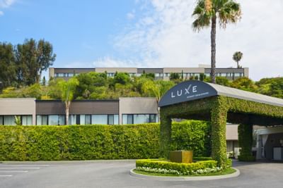 Entrance with green trees around at Luxe Sunset Boulevard