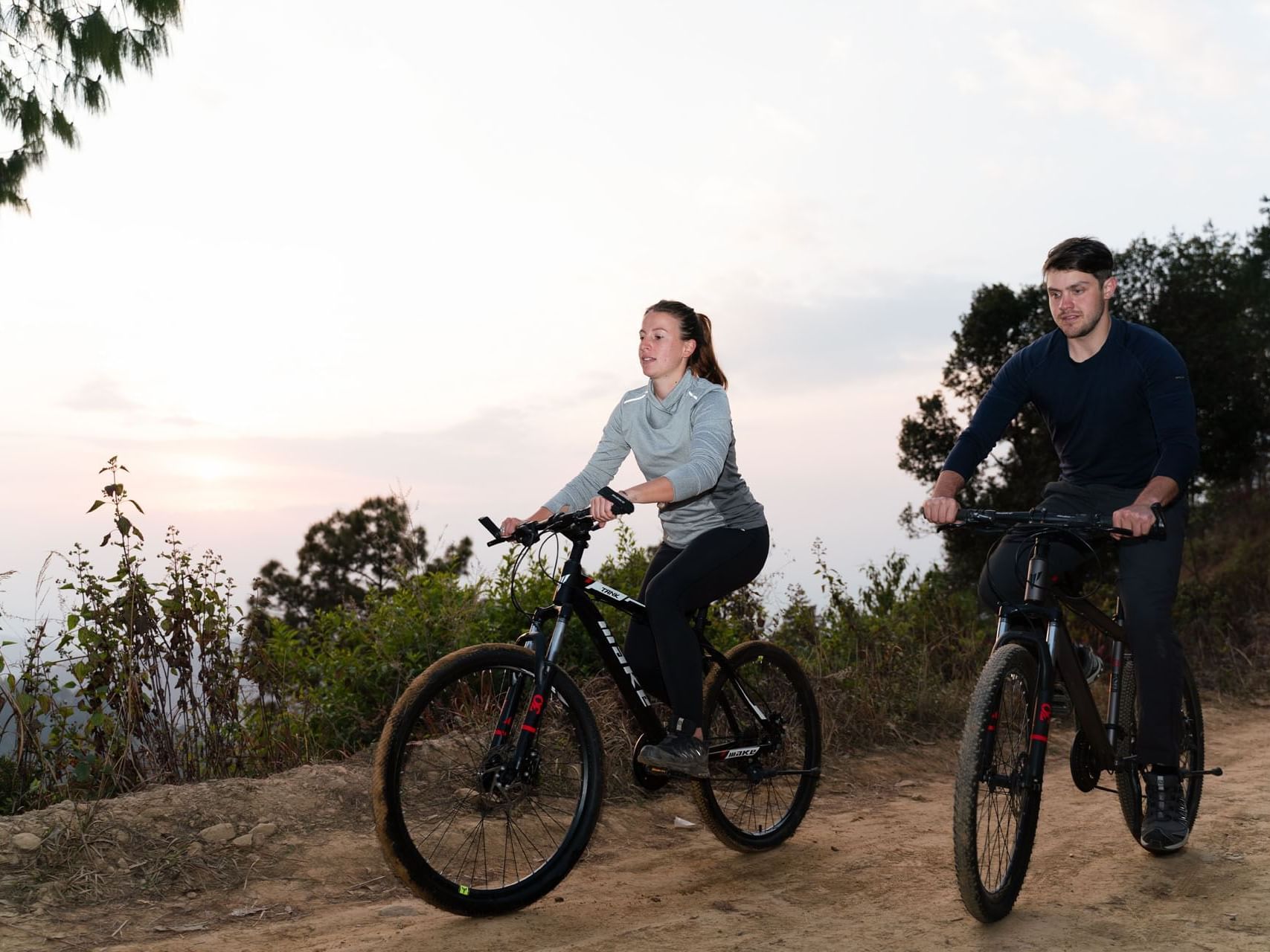 Two cyclists on mountain bikes outdoors at sunset near The Terraces Resort & Spa