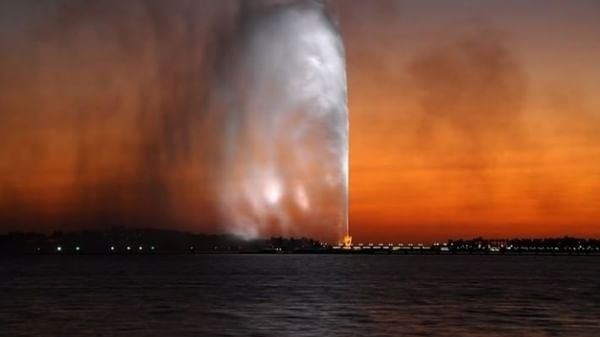 King Fahd's Fountain by the dark sea under a vibrant orange sunset near Warwick Jeddah Hotel & Spa