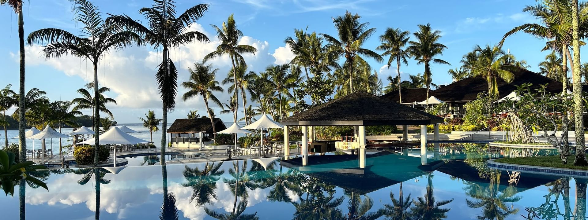 Large pool and beach terrace area with palm trees at Warwick Le Lagon - Vanuatu in Efate.