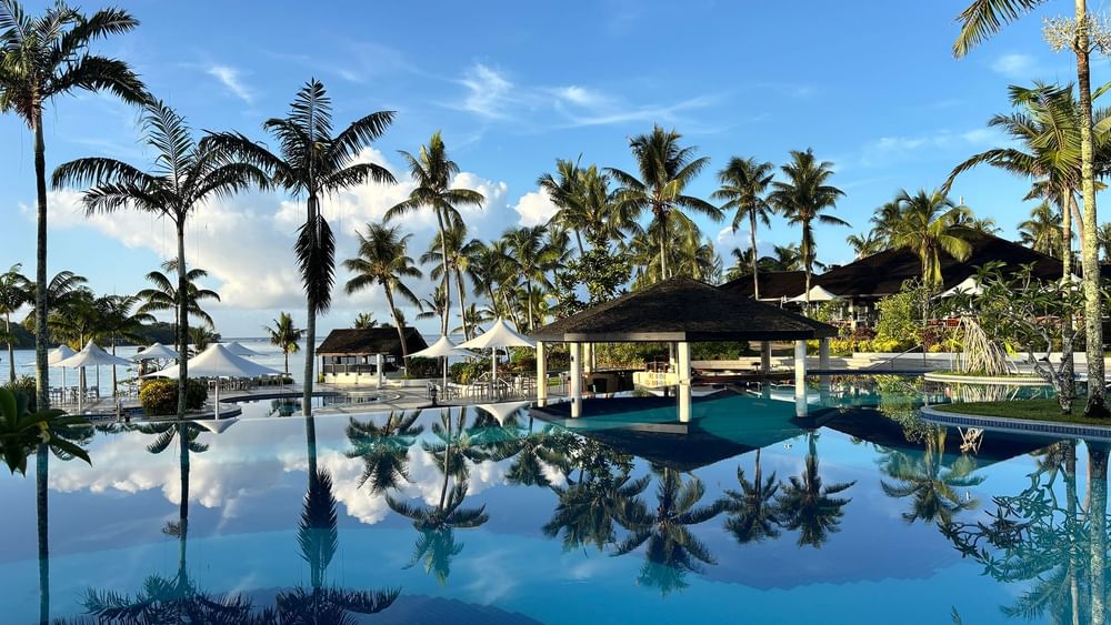 Large pool and beach terrace area with palm trees at Warwick Le Lagon - Vanuatu in Efate.