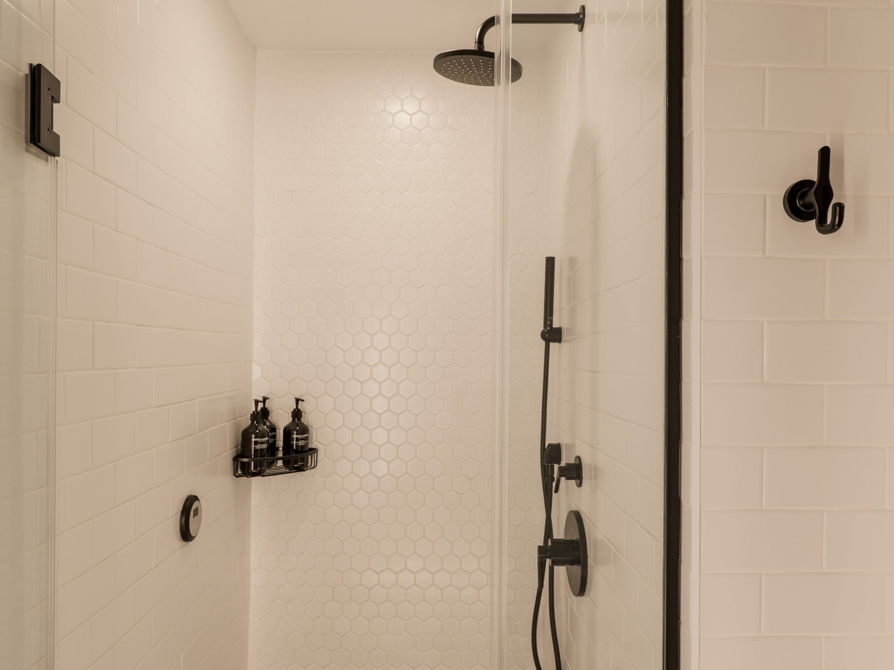 White tiled shower with black fixtures in Two-Bedroom Manhattan Suite at Gansevoort Meatpacking NYC in New York.