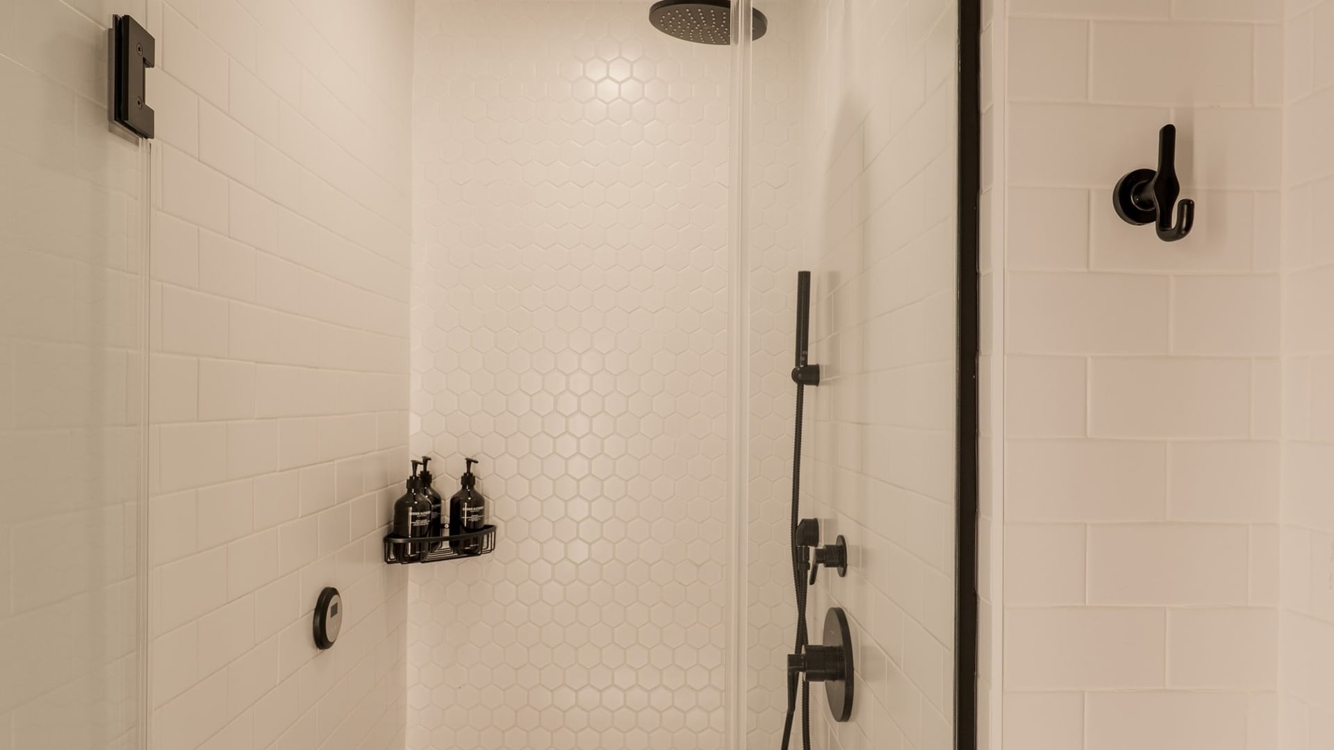 Modern white-tiled shower with black fixtures and rainfall showerhead at Gansevoort Meatpacking NYC - NEW.